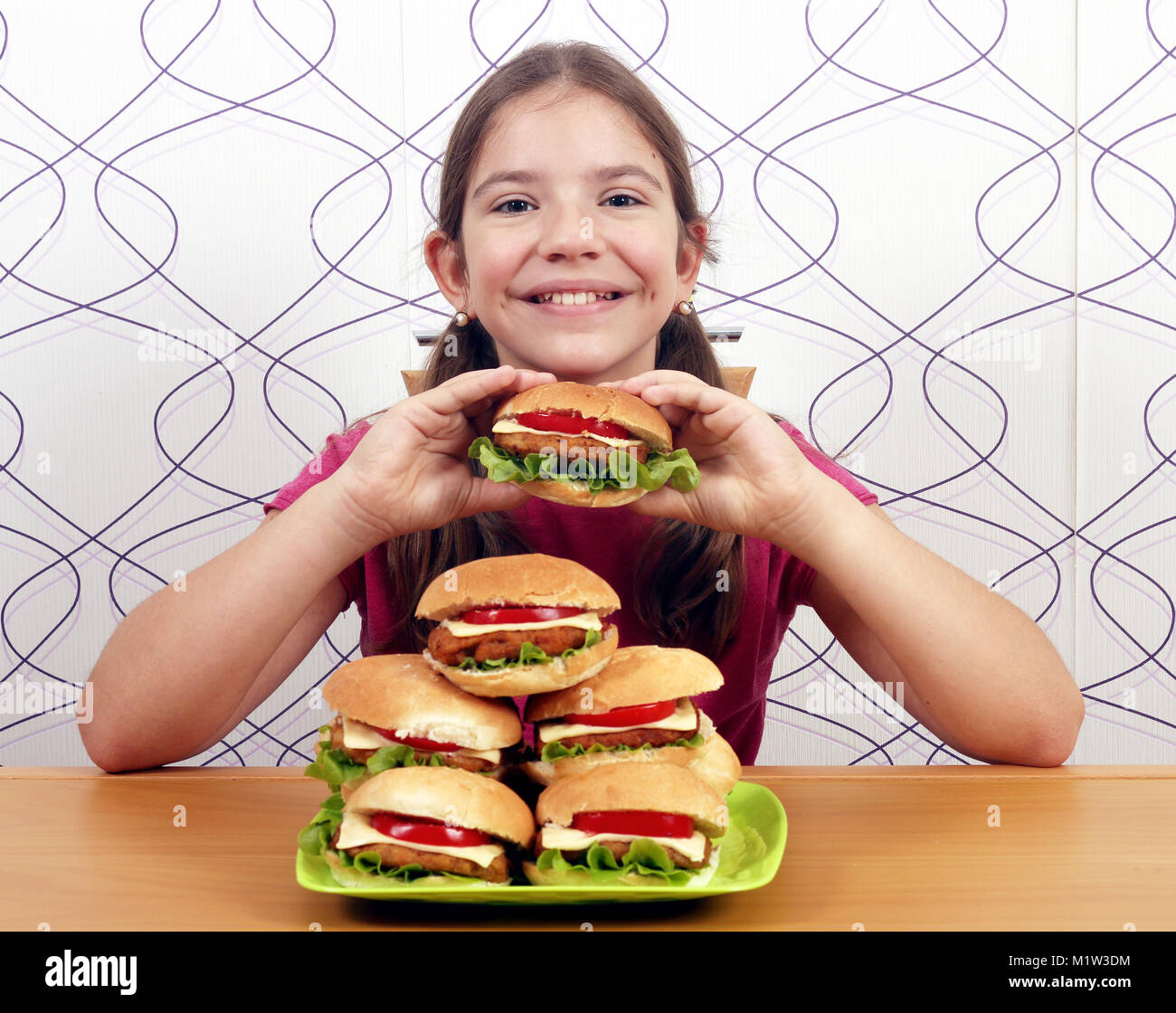 Glückliche kleine Mädchen mit Hamburger Stockfoto