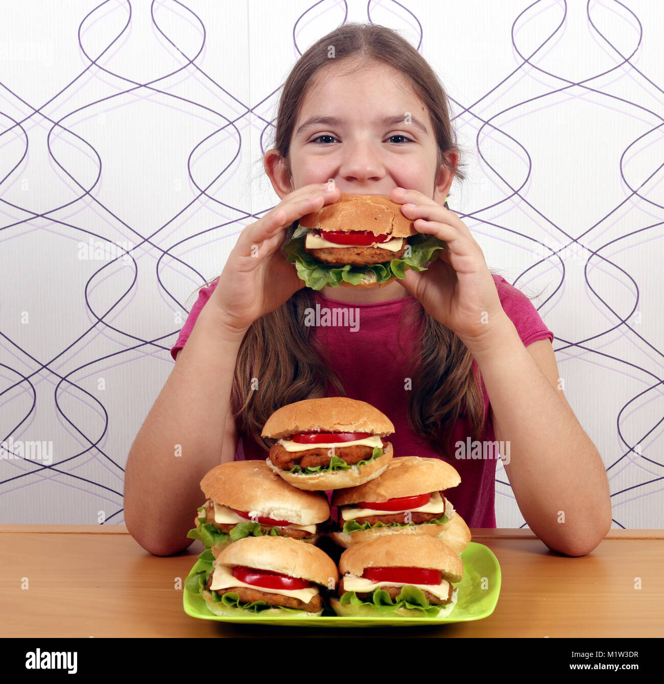 Hungrige kleine Mädchen essen Hamburger Stockfoto