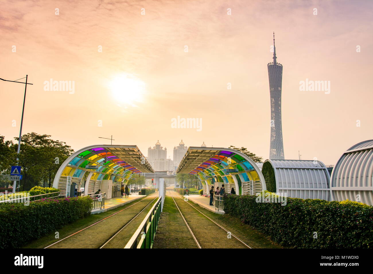 GUANGZHOU, China - 3. JANUAR 2018: Guangzhou City Tram Station mit Gras Rail Track abgedeckt und Canton Tower im Hintergrund Stockfoto