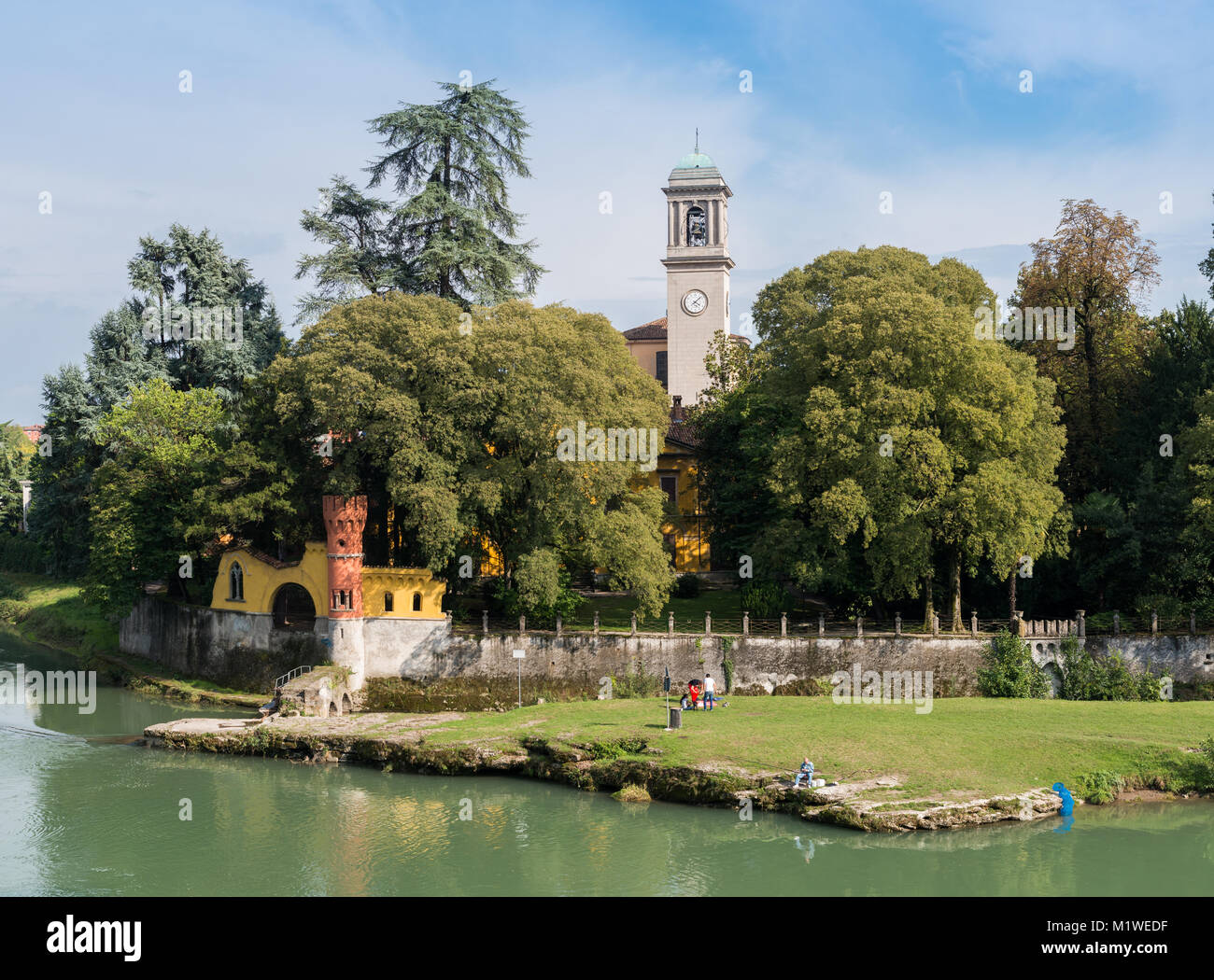 Fischer neben einem churchtower in Cassano d'Adda, Italien entspannen Stockfoto