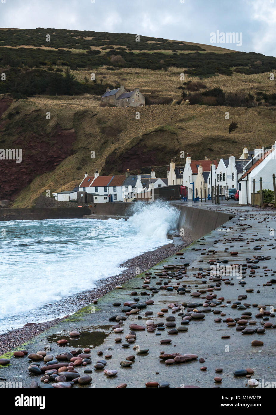 Pennan, Aberdeenshire, Schottland, Großbritannien, 2. Februar 2018. Die starken Winde warfen Steine auf die Promenade und erzeugen eine Brandung in der Nordsee entlang der Nordostküste Schottlands, mit großen Wellen, die das malerische Dorf bespritzen, das berühmt ist als Drehort für den Film "Local Hero" Stockfoto