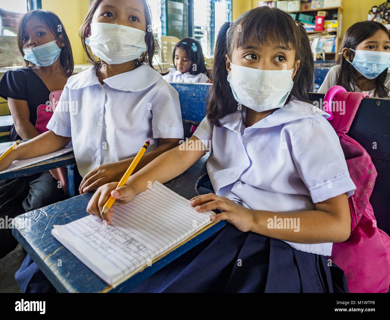 Guinobatan, Albay, Philippinen. 22 Jan, 2018. Studenten an Muladbucad Grande Volksschule in Guinobatan tragen Gesichtsmasken in der 1. Klasse. Mehrere Gemeinden in Guinobatan geschlagen Asche fällt aus die Eruptionen der Mayon Vulkan und viele Menschen trugen Gesichtsmasken selbst aus der Asche zu schützen. Es gab eine Reihe von Eruptionen auf der Mayon Vulkan in der Nähe von Legazpi Montag. Die Eruptionen begann Sonntag Nacht und weiter durch den Tag. Um ca. 12.00 Uhr den Vulkan gesendet eine Wolke aus Asche und Rauch hoch über Camalig, die größte Gemeinde in der Nähe des Vulkans. Die philippinische Ins Stockfoto