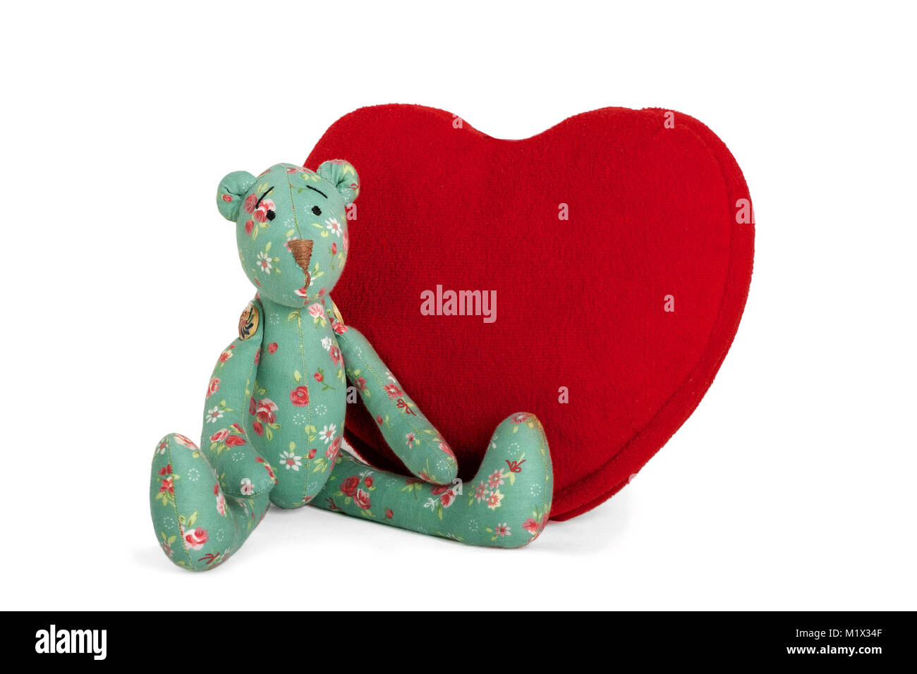 Grüne Teddybär Sitzplätze in der Nähe große rote Herzen, isoliert Stockfoto