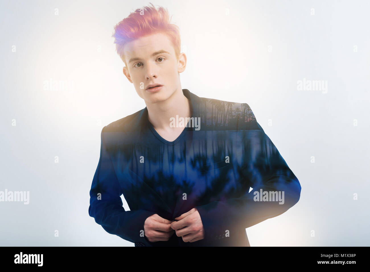 Angenehm schöner Mann stehen und berührend zu seiner Jacke. Stockfoto