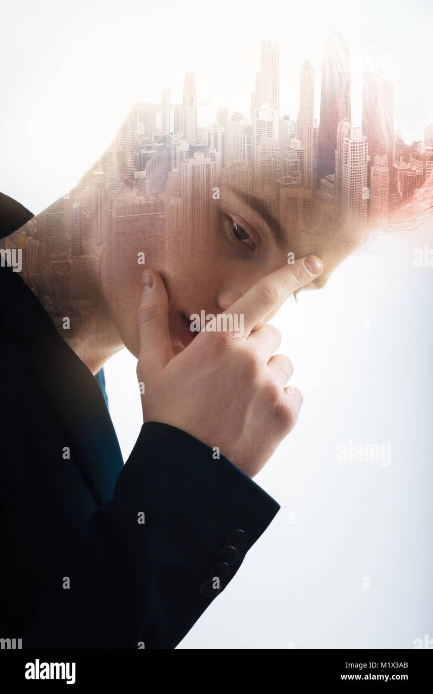 Tief ernster Mann Neigekopf und berührend sein Gesicht. Stockfoto