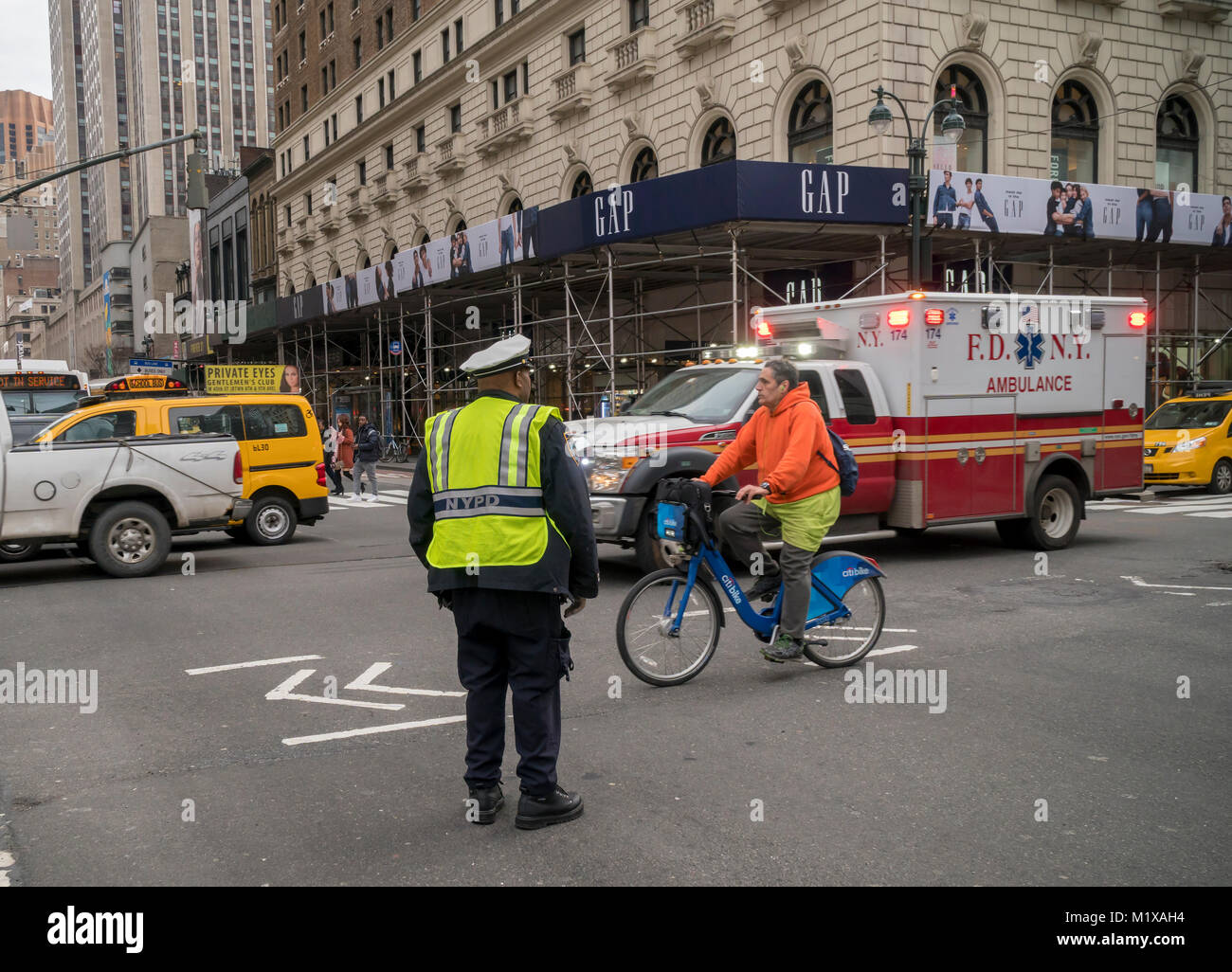 Eine NYPD traffic Enforcement Agent ermöglicht ein Krankenwagen durch in der Herald Square in New York am Samstag, 27. Januar 2018 übergeben. New York erwägt eine Staugebühr pricing Plan, der Fahrer, die unter 60th Street in Manhattan travel aufladen würde. (Â© Richard B. Levine) Stockfoto