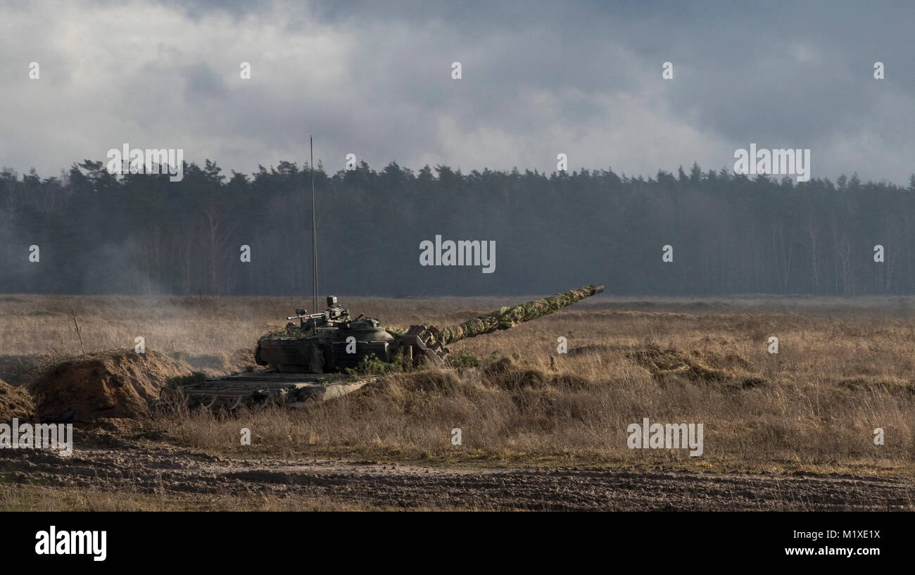 Eine polnische Tank vom 1.Bataillon, 15 mechanisierte Brigade, bietet Unterstützung für die US-Soldaten aus der 3. Staffel, 2. Kavallerie Regiments, während Sie an einem NATO-live fire Übung von der Polnischen 1-15 Mech koordinierte teilnehmen. BN in einem Bereich in der Nähe der Bemowo Piskie, Polen, Jan. 30, 2018. Die einzigartige, multinationalen Battle Group, bestehend aus USA, Großbritannien, Kroatischen und Rumänische Soldaten dienen, die mit der polnischen 15 mechanisierte Brigade als Abschreckung Kraft im Nordosten Polens in der Unterstützung der NATO-Präsenz verstärkt nach vorne. (U.S. Armee Stockfoto