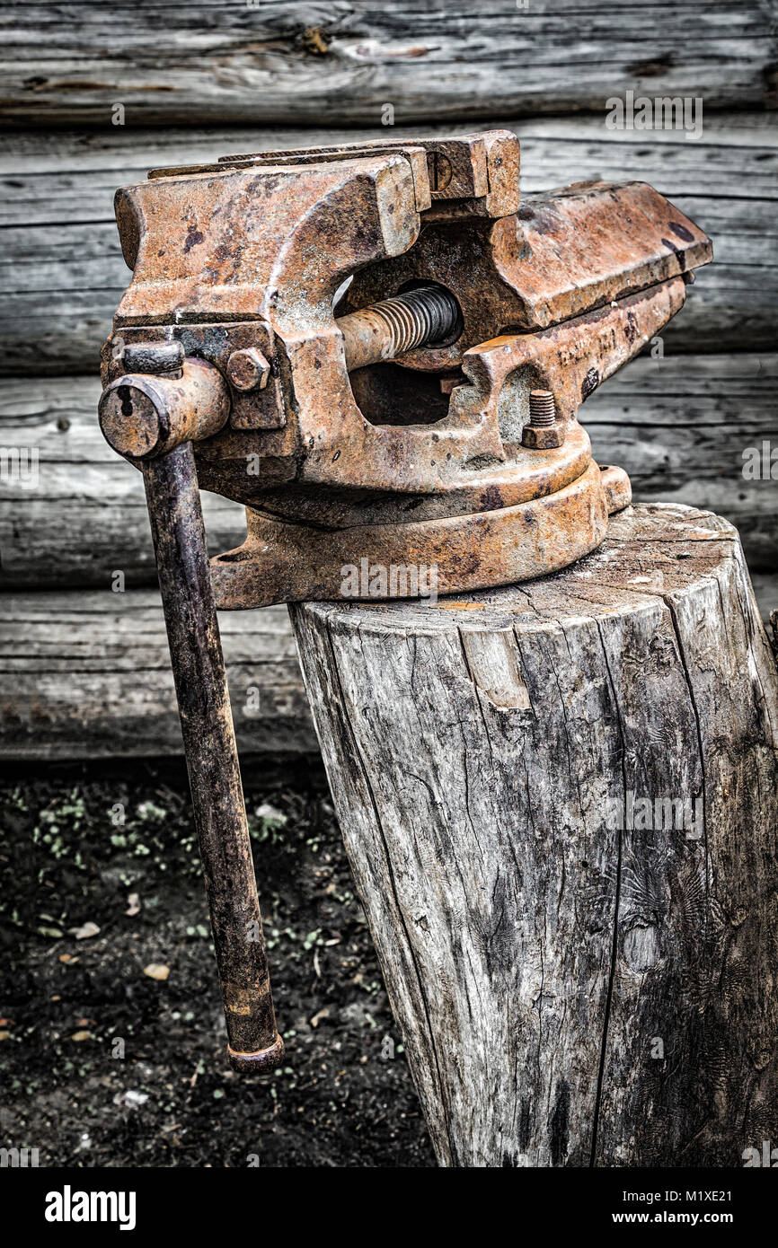 Alten rostigen Vice stehend auf einem Baumstumpf im Hinterhof. Stockfoto