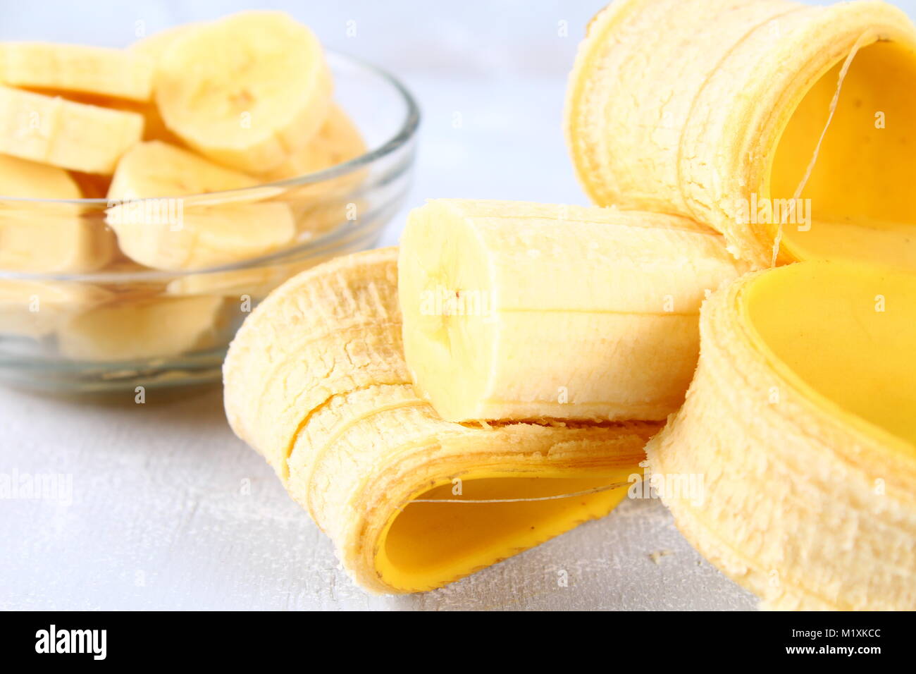 Bananen sind das ganze und auf einer Schicht in einer Schale auf einem grauen Hintergrund ausschneiden Stockfoto