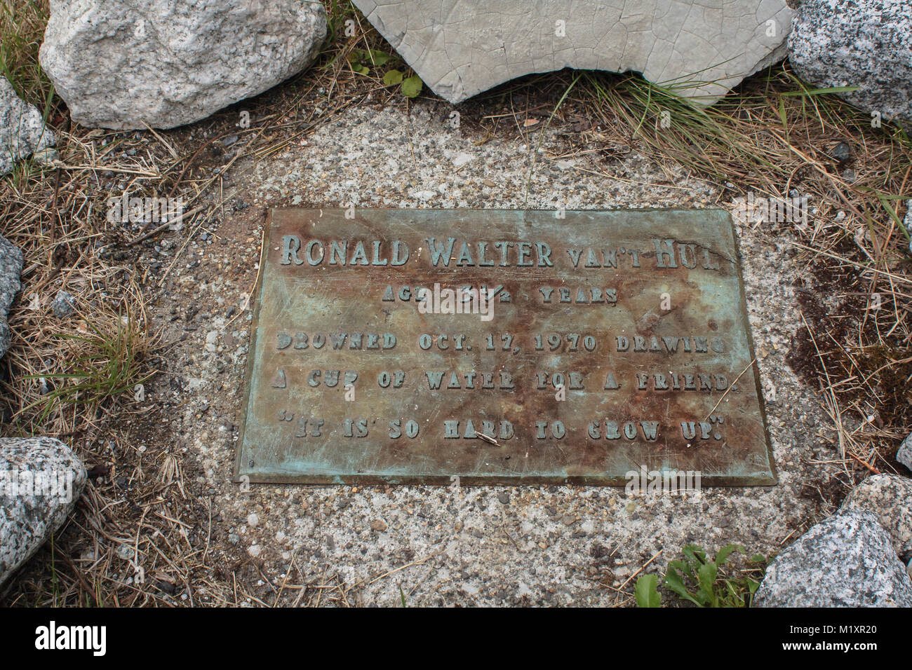 Eine Messingplakette inmitten eines Kreises von großen Steinen dient als ein Denkmal für einen Jungen, der durch Ertrinken in einer kleinen Gemeinschaft in British Columbia gestorben. Stockfoto