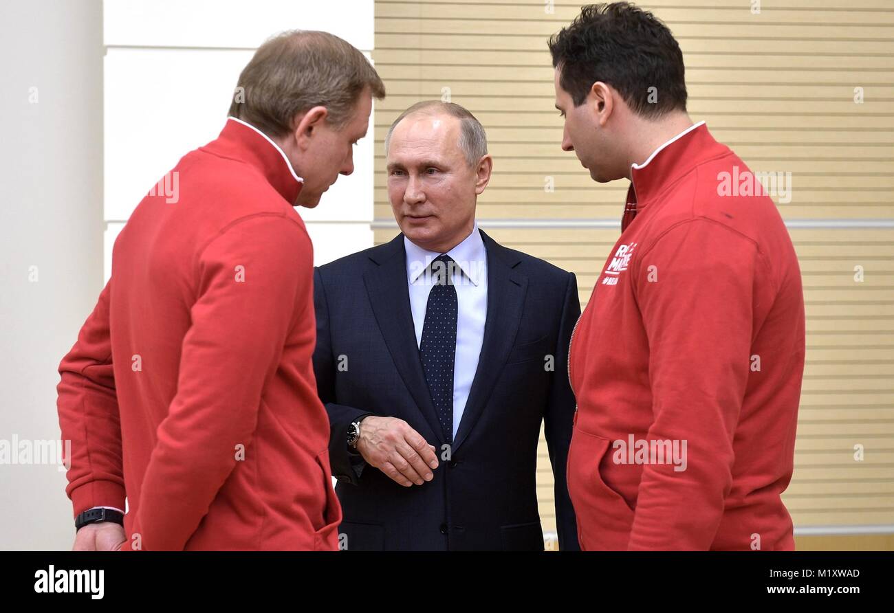 Der russische Präsident Wladimir Putin Chats mit Russischen Ice Hockey Federation Vice President römischen Rotenberg, rechts, und Athleten und Trainer konkurrieren in der PyeongChang Olympischen Winterspiele Januar 31, 2018 in Novo-Ogaryovo, Moskau, Russland. Stockfoto
