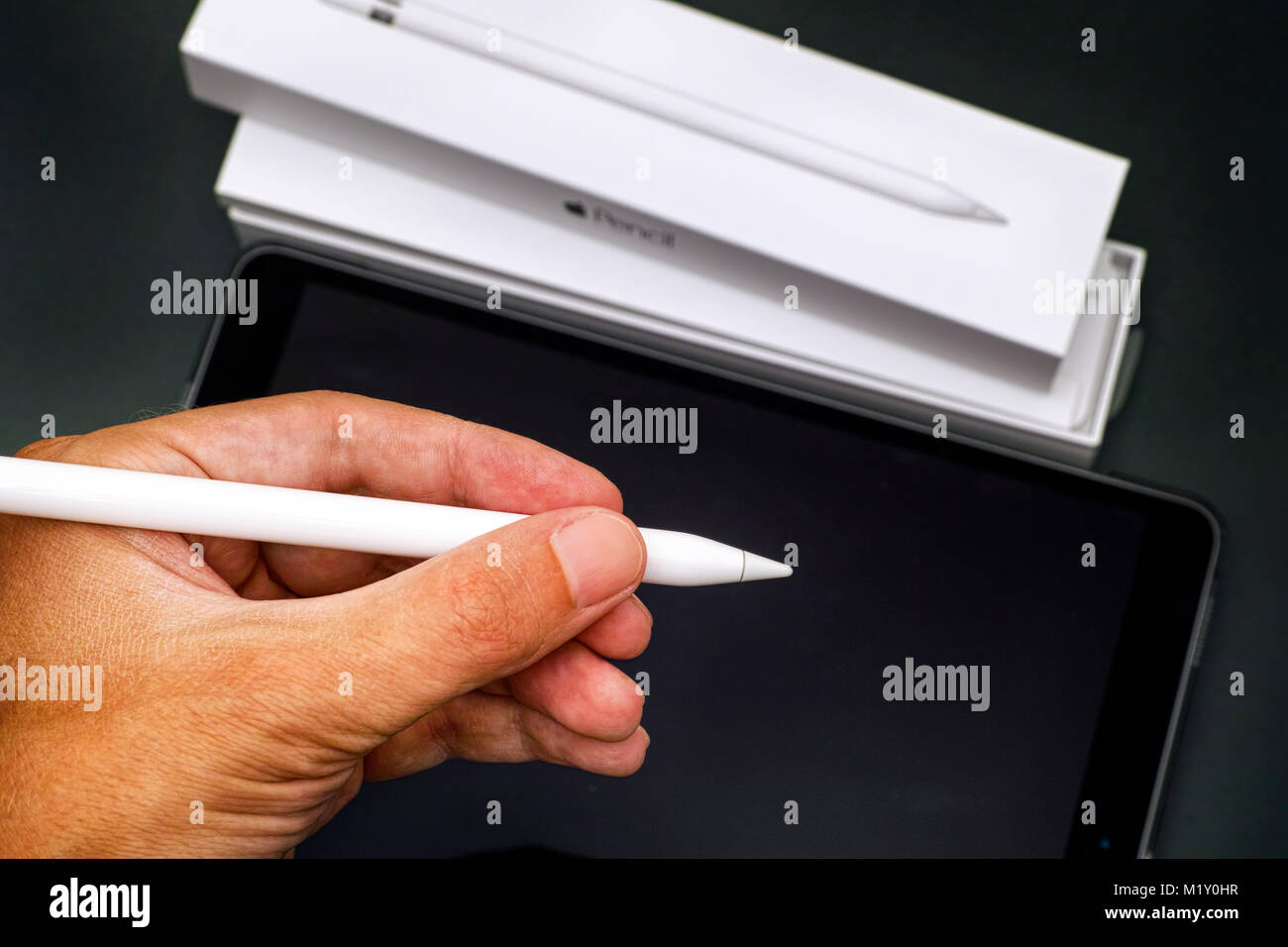 Tambow, Russische Föderation - August 23, 2017 Apple Bleistift in Person hand mit Apple iPad Pro 10.5. und Bleistift. Dunkelgrünen Hintergrund. Studio gedreht. Stockfoto