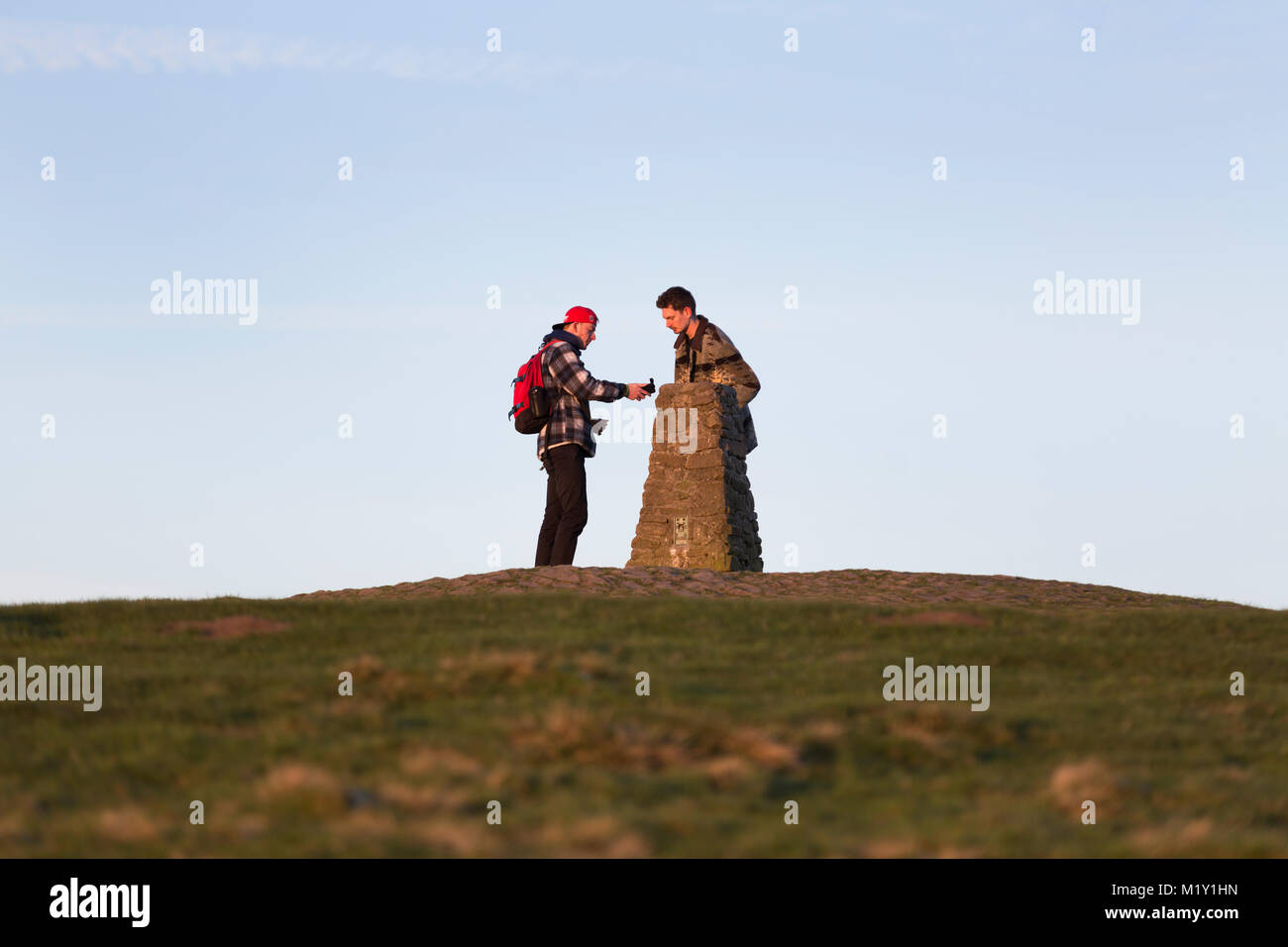 Großbritannien, Derbyshire, zwei Wanderer die trigonometrischen Punkt auf Mam Tor prüfen. Stockfoto