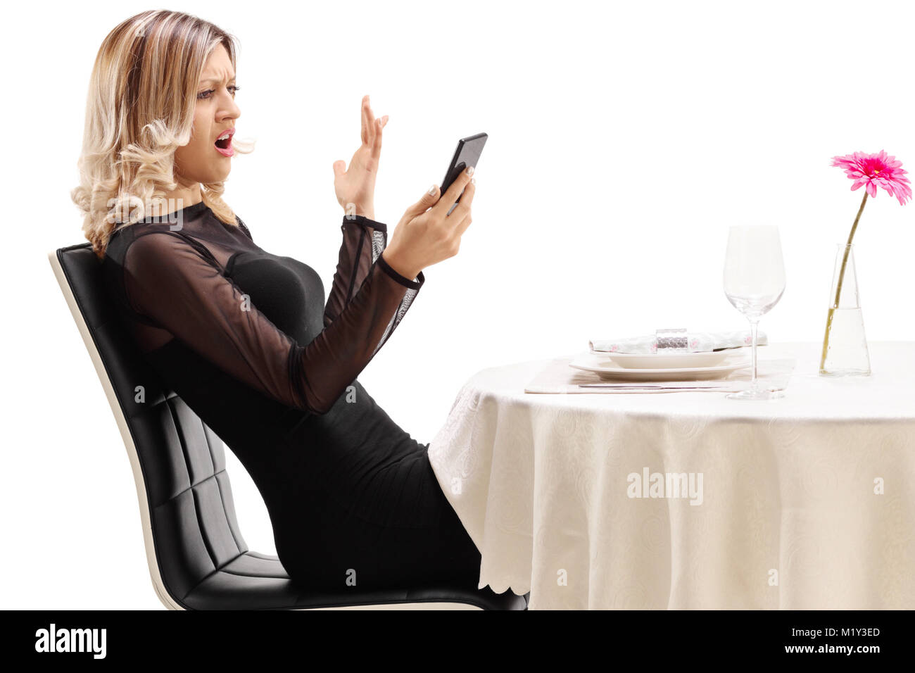Unzufrieden Frau an einem Tisch im Restaurant sitzen an Ihrem Telefon auf weißem Hintergrund suchen Stockfoto