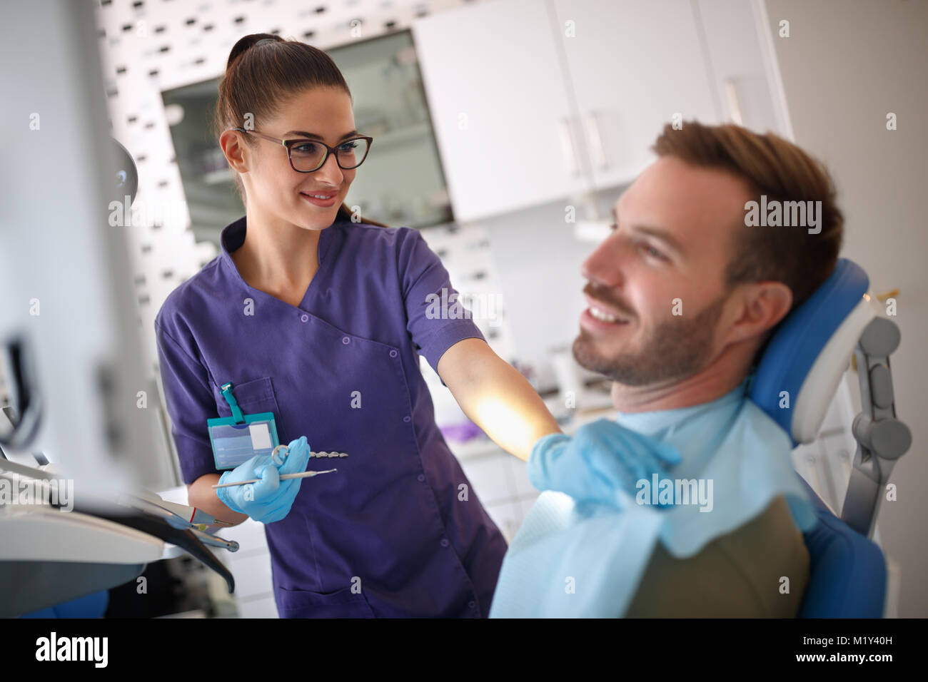 Weiblichen Zahnarzt vorbereiten männliche Patienten für zahnärztliche Behandlung Stockfoto