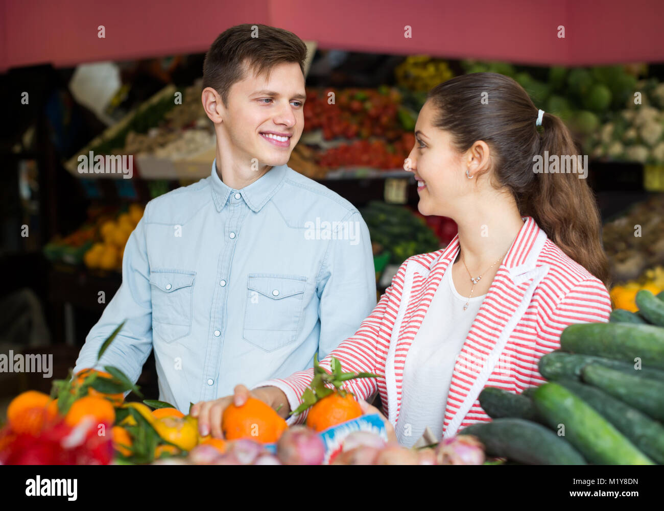 Freudige junge Paar Auswahl von Obst und Gemüse auf dem Markt Stockfoto