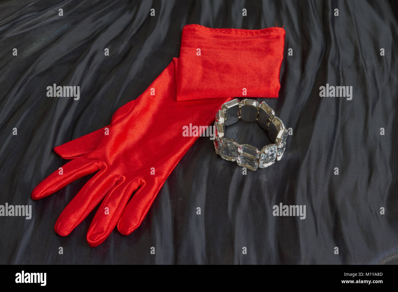 Schöne und elegante rote Handschuh und Halskette auf dunklem Hintergrund Stockfoto Schöne und elegante rote Handschuh und Halskette auf dunklem Hintergrund Stockfoto