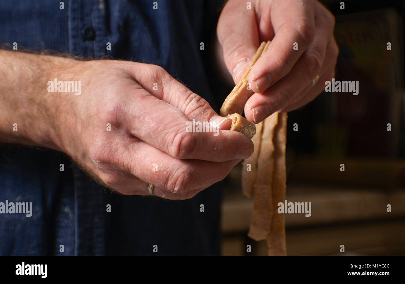 Entfaltet sich der Mensch den Teig für pasta Seitenansicht horizontal Stockfoto