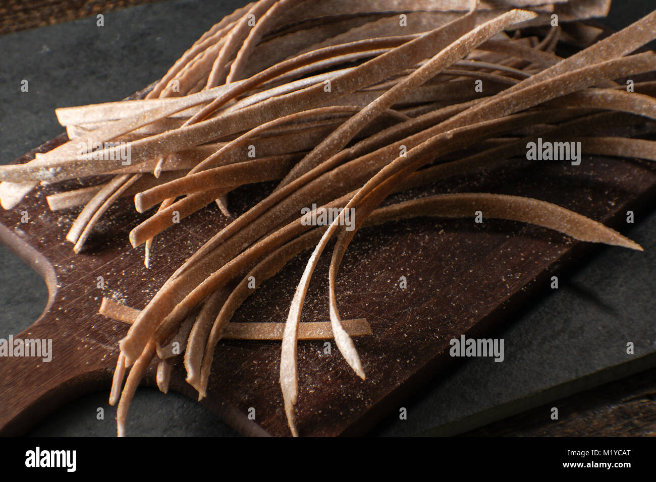 Trockene Paste aus Vollkornmehl auf einem Holzbrett horizontal Stockfoto