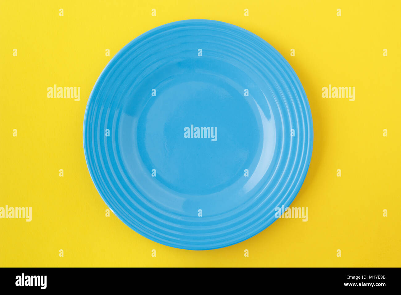 Leeren blauen Platte auf Gelb. Von oben betrachten. Stockfoto