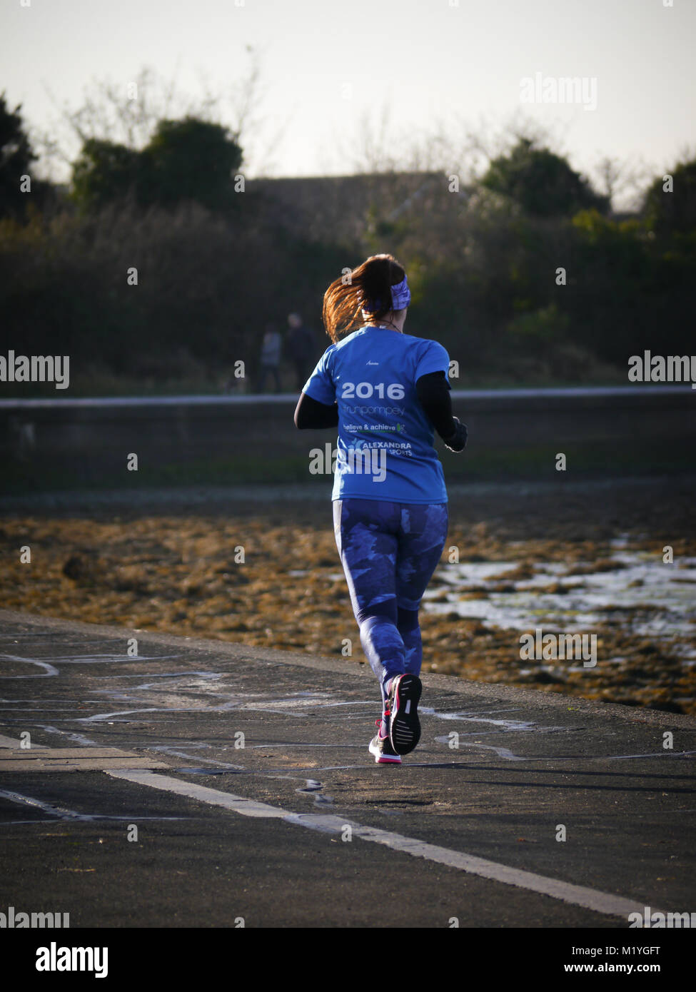 Eine junge Dame auf einem öffentlichen Fußweg laufen Stockfoto