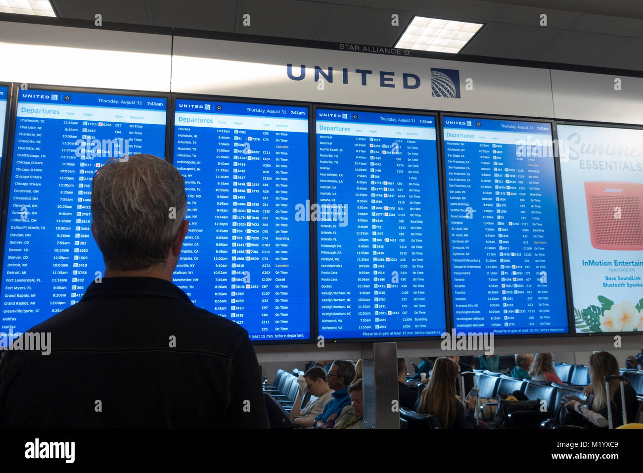 Ein Mann Kontrolle der Abreise Board für United Airlines in Newark International Airport, (Anschlußklemme C), New Jersey, United States. Stockfoto