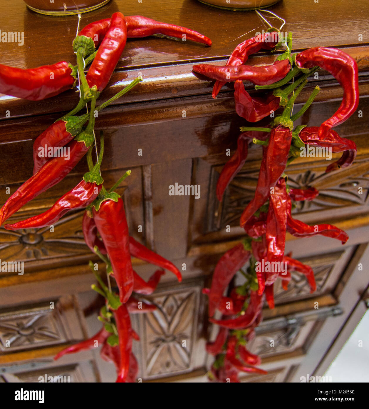 Bio rote Chilis oder Chilischoten Trocknen im alten und antiken Möbeln eingerichtet. Paprika mit einem Seil gebunden, traditionelle Methode der Trocknung. Stockfoto