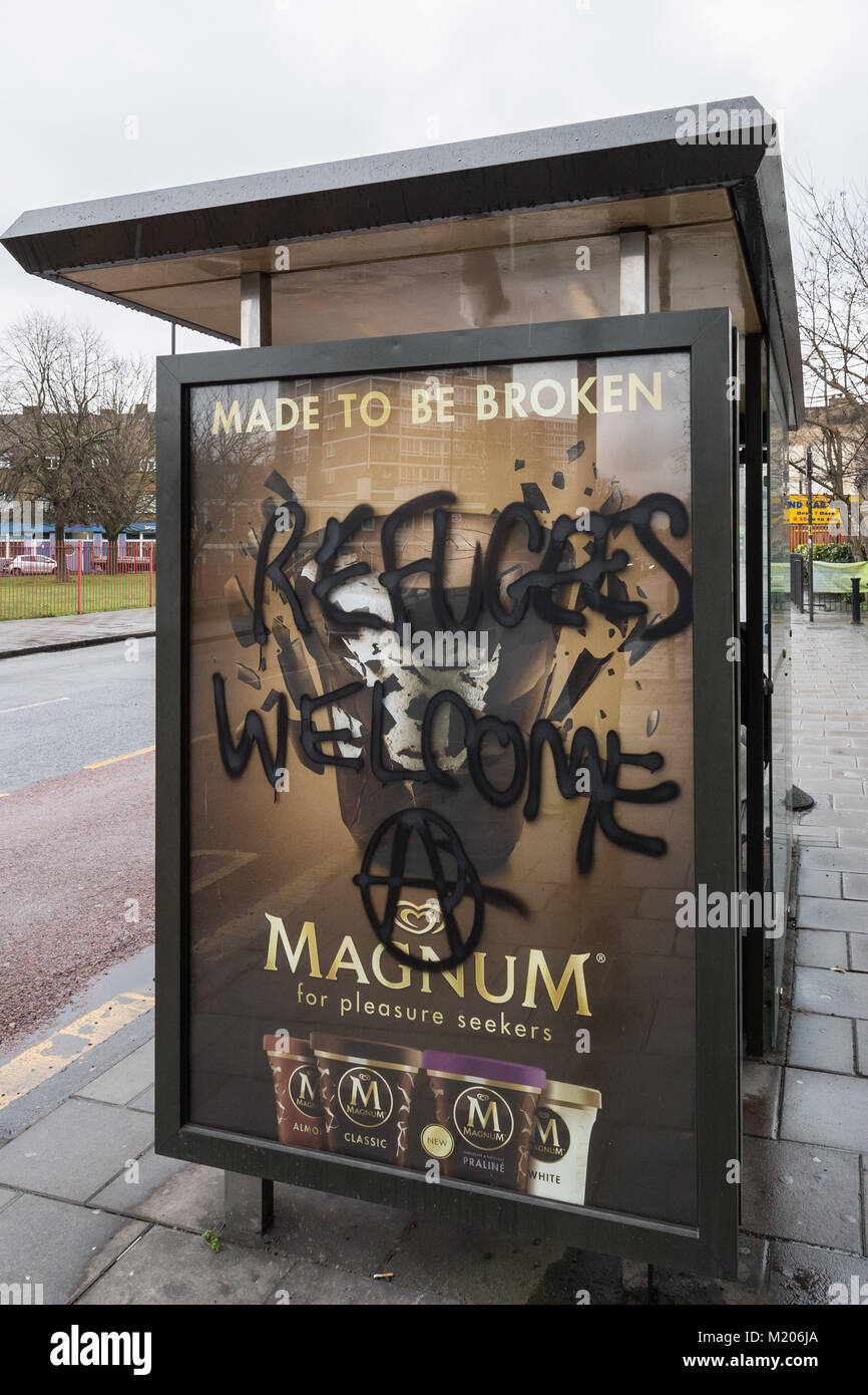 "Die Flüchtlinge Willkommen' Spray malte auf einer Bushaltestelle von der Londoner Anarchisten in Deptford, South East London, UK. Stockfoto