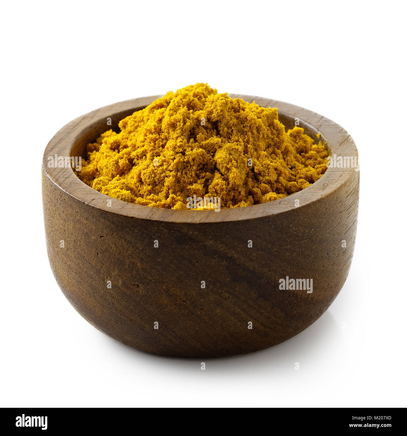 Curry Pulver in dunklem Holz Schüssel isoliert auf Weiss. Stockfoto