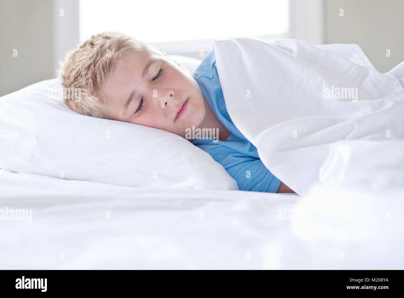 Junge schlafend mit dem Kopf auf das Kopfkissen. Stockfoto