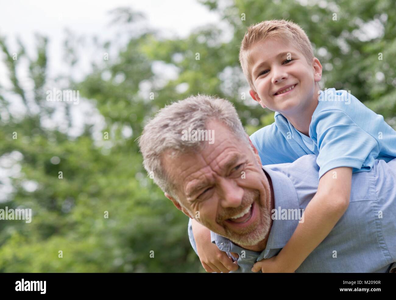 Großvater und Enkel eine piggy zurück. Stockfoto