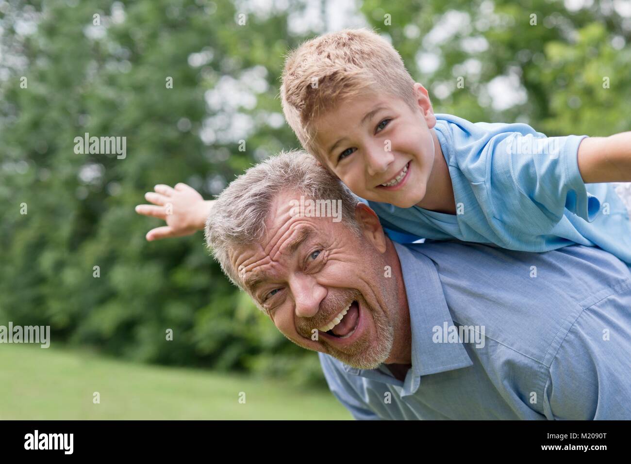 Großvater und Enkel eine piggy zurück. Stockfoto