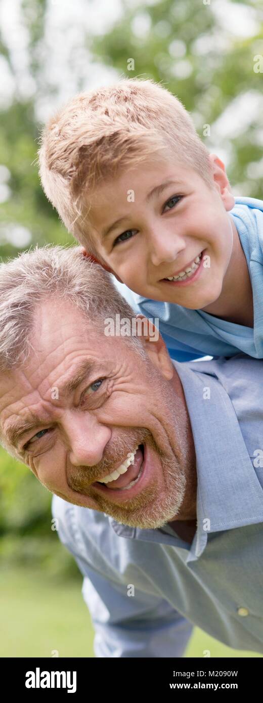 Großvater und Enkel eine piggy zurück. Stockfoto