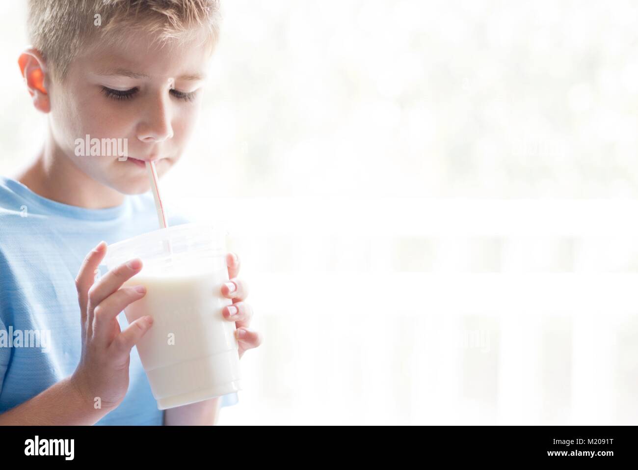 Porträt eines jungen Trinken der Milch durch einen Strohhalm. Stockfoto