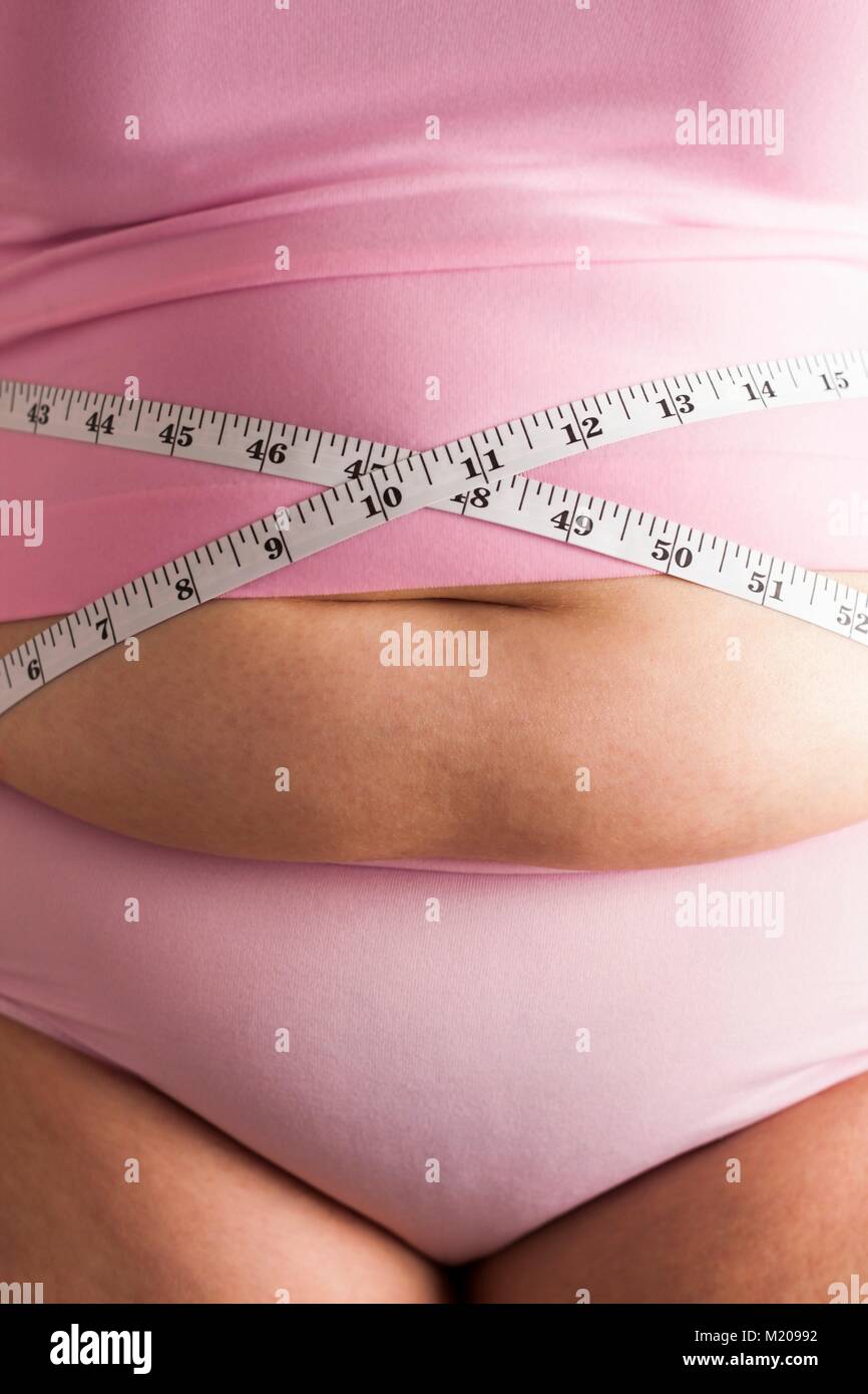 MODEL RELEASED. Frau messen Taille mit Maßband. Stockfoto