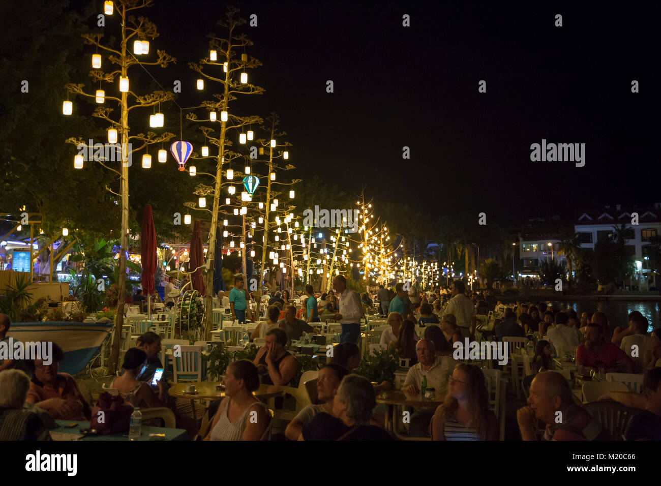 Elegante Menschen mit Abendessen in der Nähe des Meeres im Open Air Restaurant Stockfoto