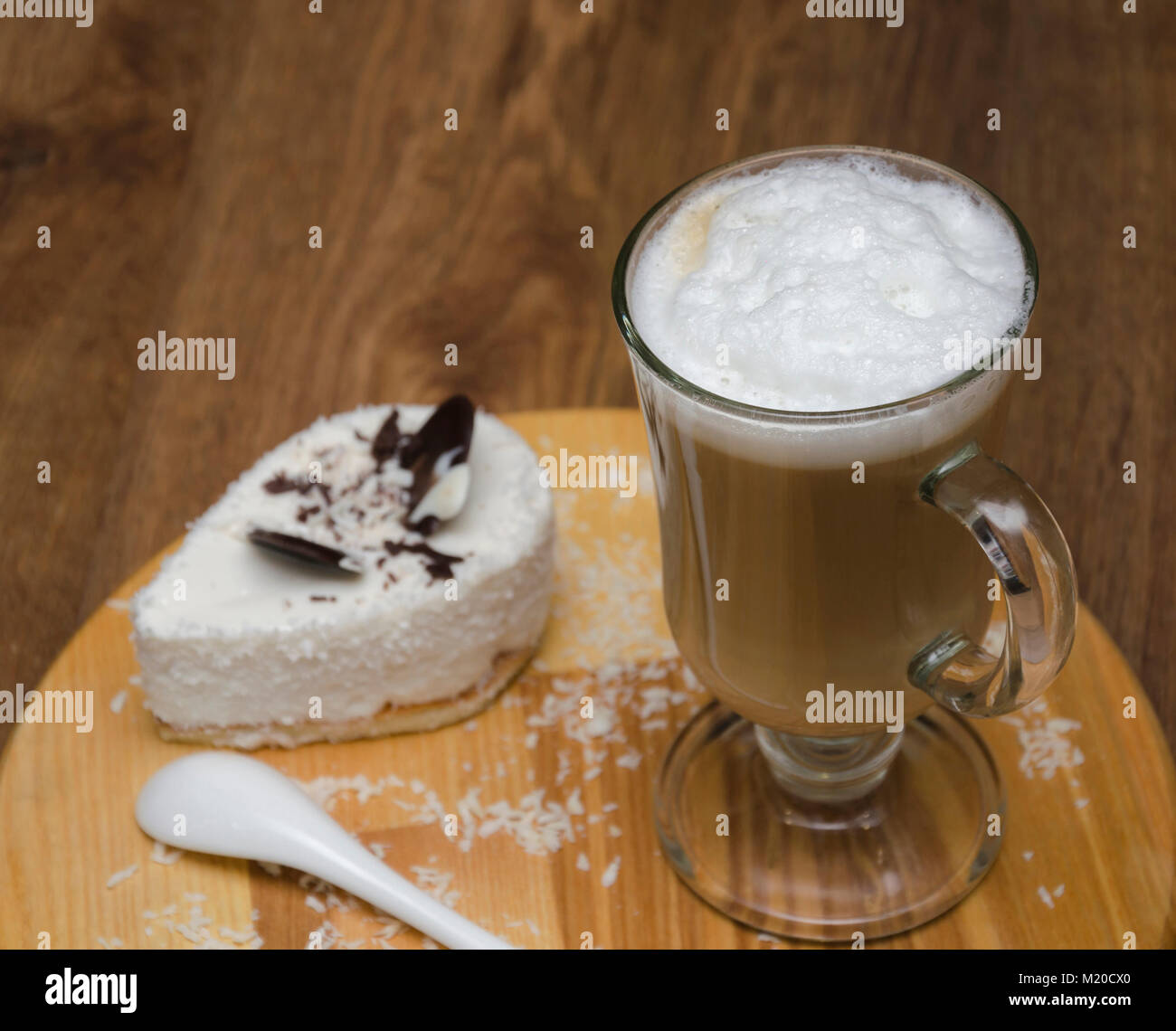 Heißes Getränk und Kaffee und Milch, Latte, Cappuccino, in einem schönen Glas Schale und Dessert, auf einem Holztisch Stockfoto