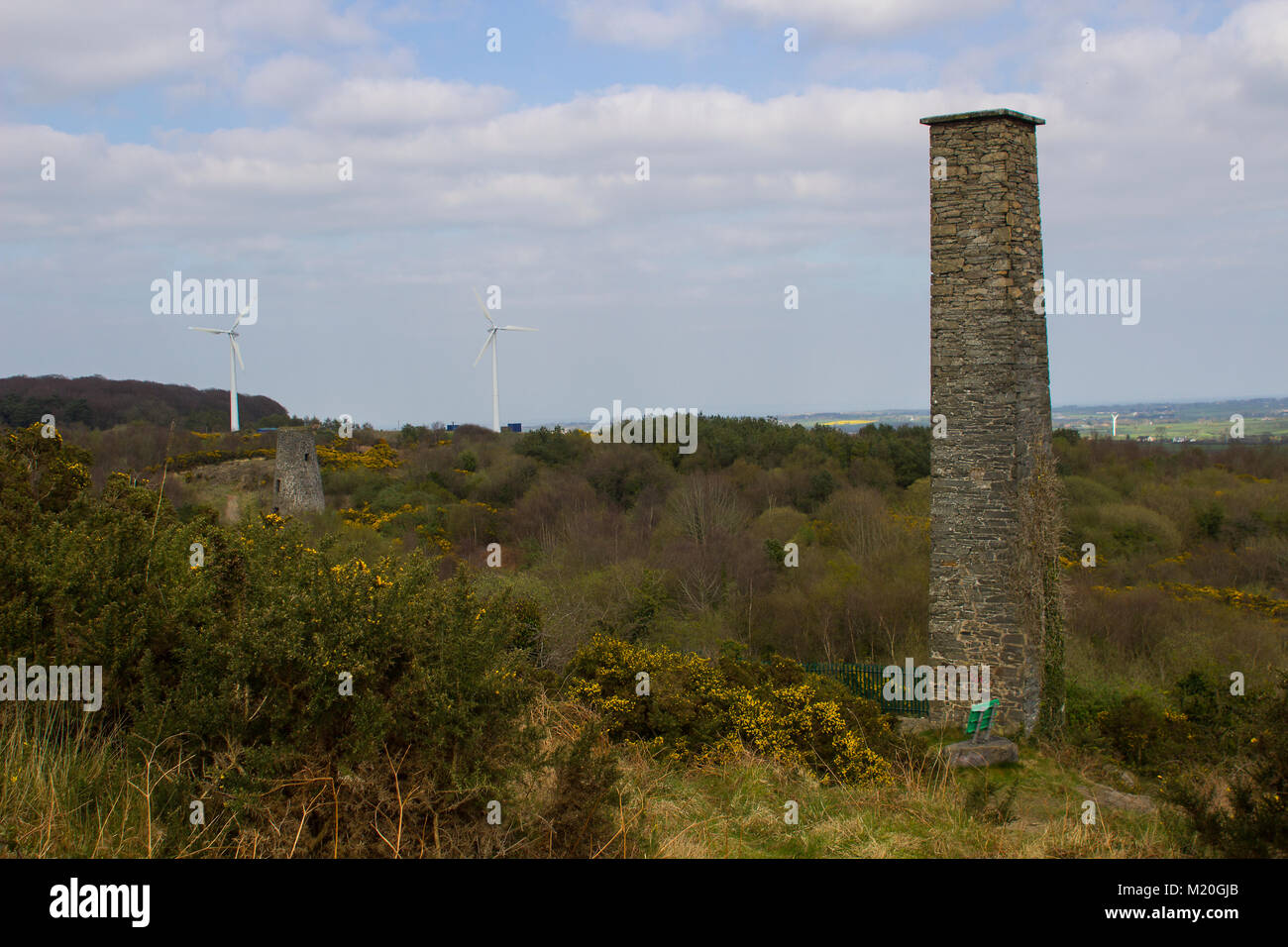 Eine alte Industrie Schornstein mit modernen Windkraftanlagen im Hintergrund an der alten Minen am Whitespots im County Down in Nordirland Stapel Stockfoto