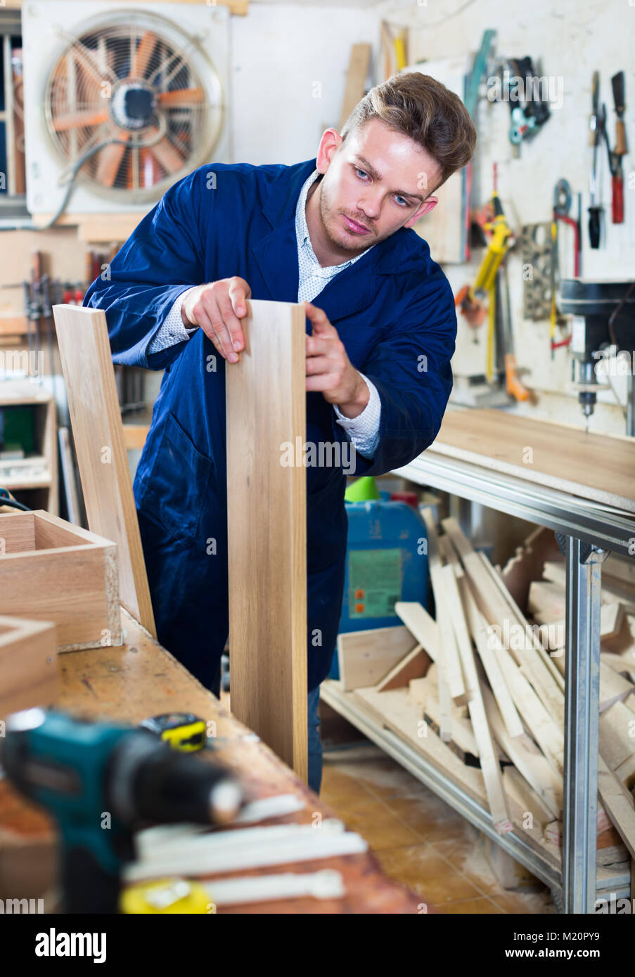 Lächelnd working man Vorbereitung Spanplatten für die Arbeit an einem seiner Werkstatt Stockfoto