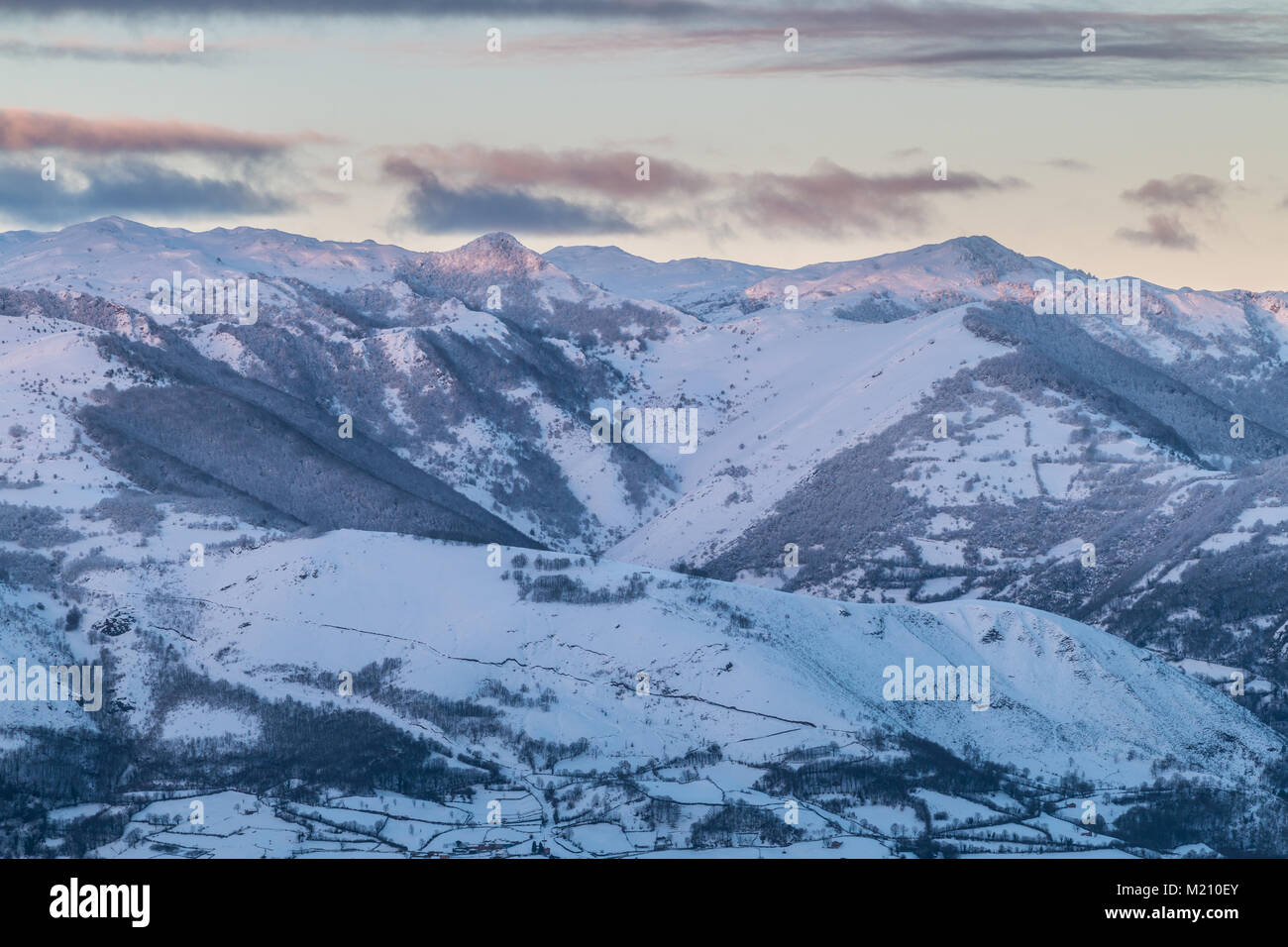 Sonnenaufgang in den Bergen von Ubina, zwischen Asturien und Leon, an einem Wintertag mit viel Schnee, in den frühen Morgenstunden zu fotografieren, die eindeutigen Farben Stockfoto