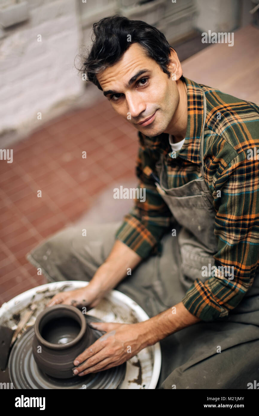 Blick auf ein Künstler macht Ton auf einem Drehrad in der Werkstatt Stockfoto