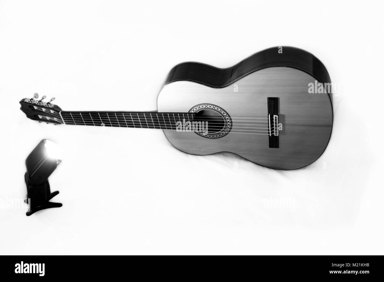 Eine klassische Gitarre vom hellen Licht eines professionellen Flash beleuchtet. Schwarz und Weiß Foto Stockfoto
