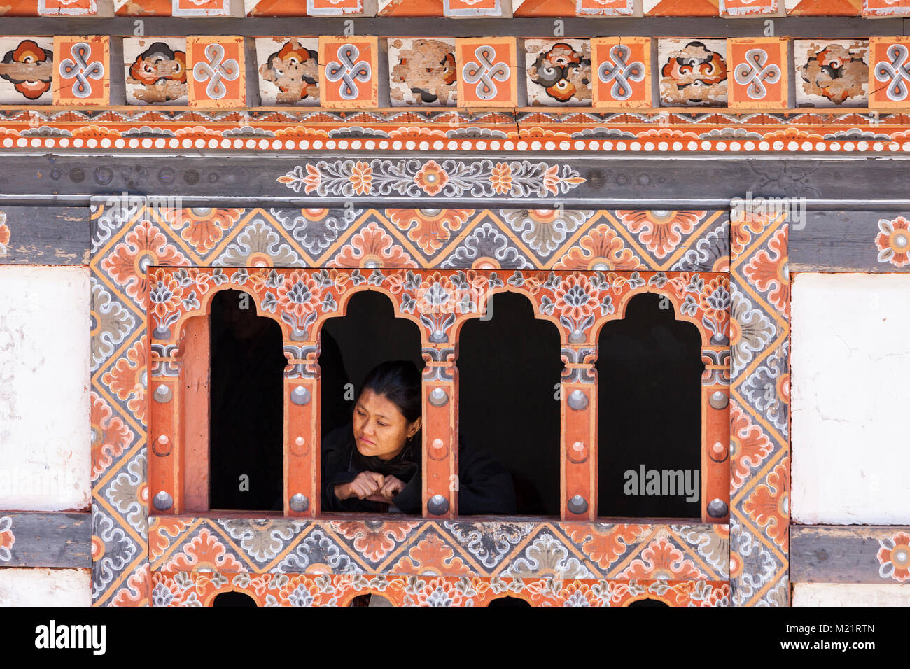 Prakhar Lhakhang, Bumthang, Bhutan. Frau beobachten Festival Tanz aus einem Fenster des Klosters. Stockfoto
