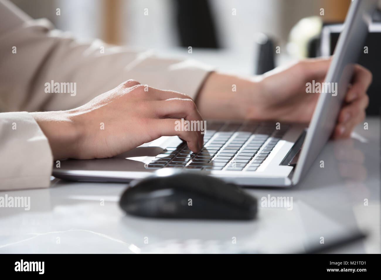 In der Nähe von Hand eintippen einer Person auf Laptop Tastatur auf dem Schreibtisch am Arbeitsplatz Stockfoto