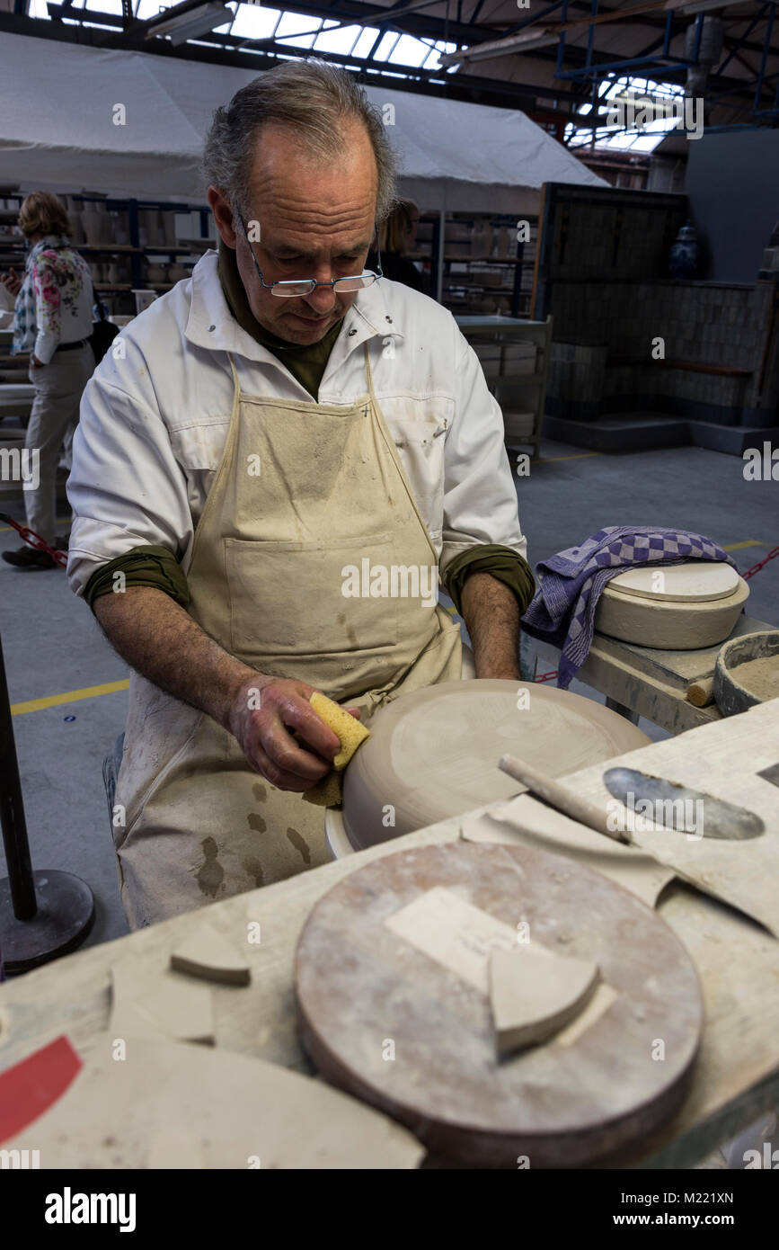 Eine qualifizierte Potter im Royal Delft Manufaktur in Delft, Holland, prüft eine Platte auf Anzeichen von Chip markiert oder raue Kanten. Das Produkt wird dann s Stockfoto