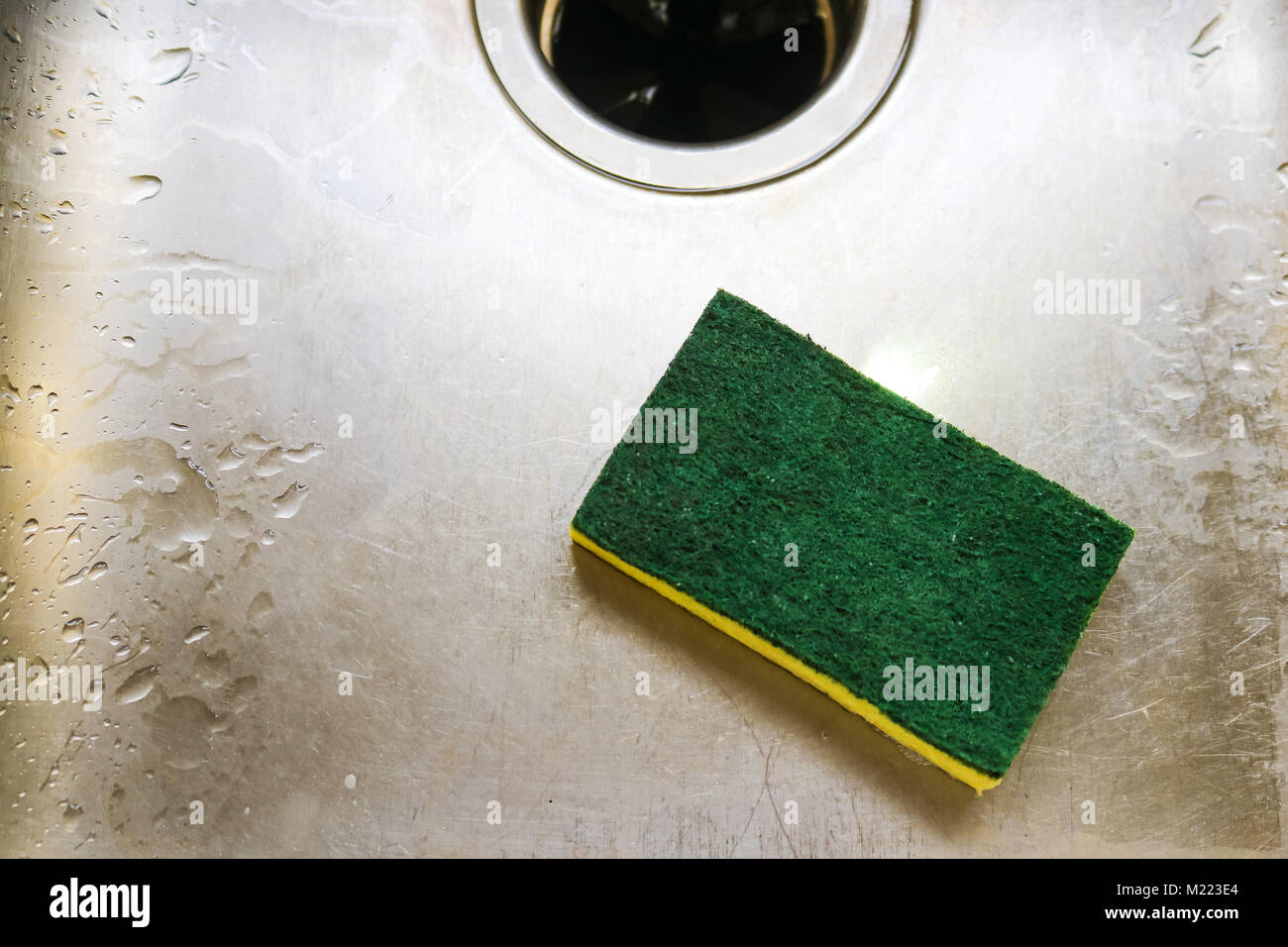 Grün und Gelb scrubing schwamm in Scratch Lügen und Wet Waschbecken mit Garage zur Verfügung Stockfoto