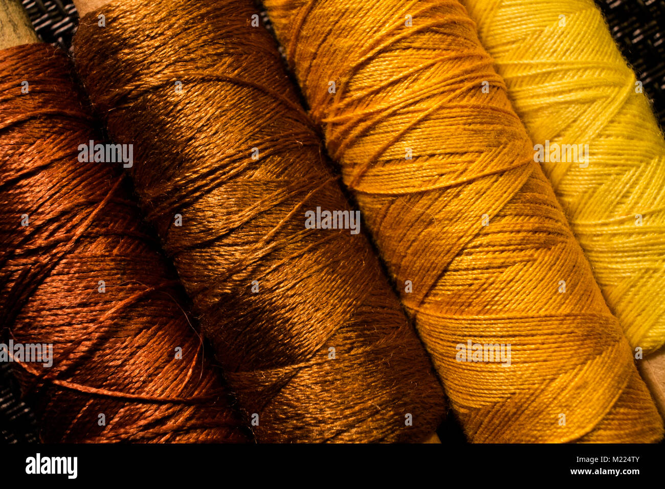 Nähgarne Spulen des gelben und braunen Farbtönen. Eine Nahaufnahme. Stockfoto