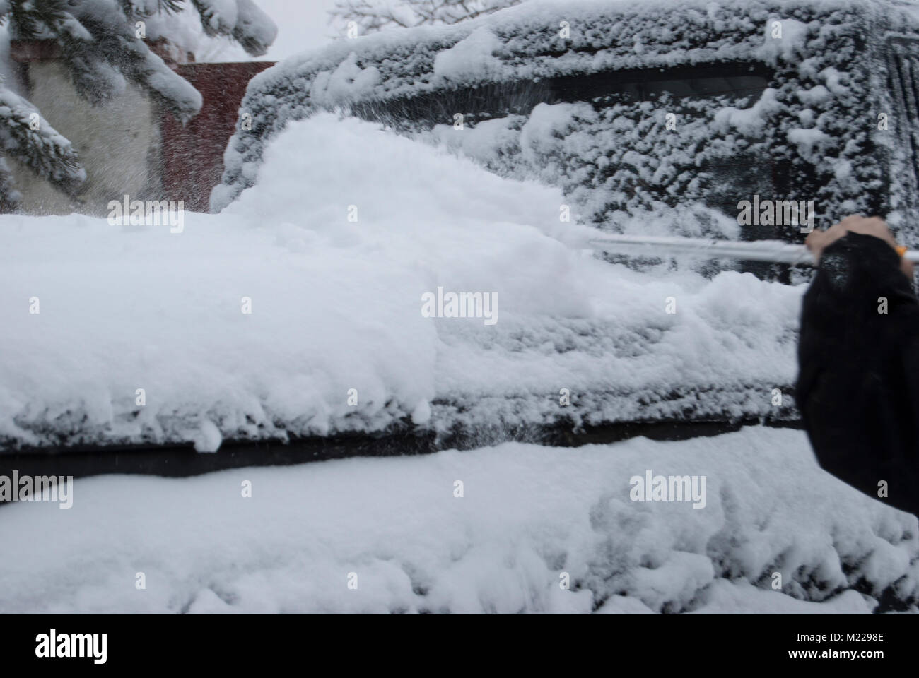 Reinigung der Kofferraum des Autos aus dem Schnee Bürste. Folgen der schweren Schneefälle. Stockfoto