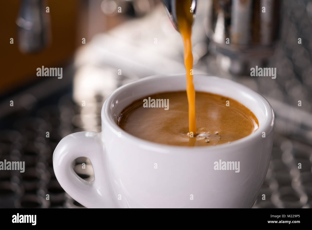 Espresso gießen in Schale mit professionellen Kaffeemaschine Stockfoto