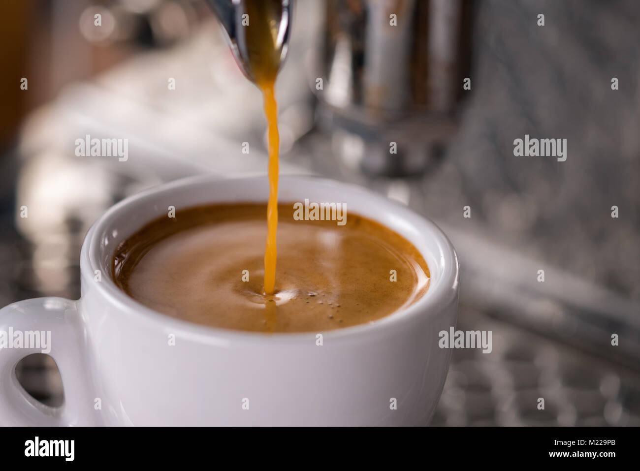 Espresso gießen in Schale mit professionellen Kaffeemaschine Stockfoto
